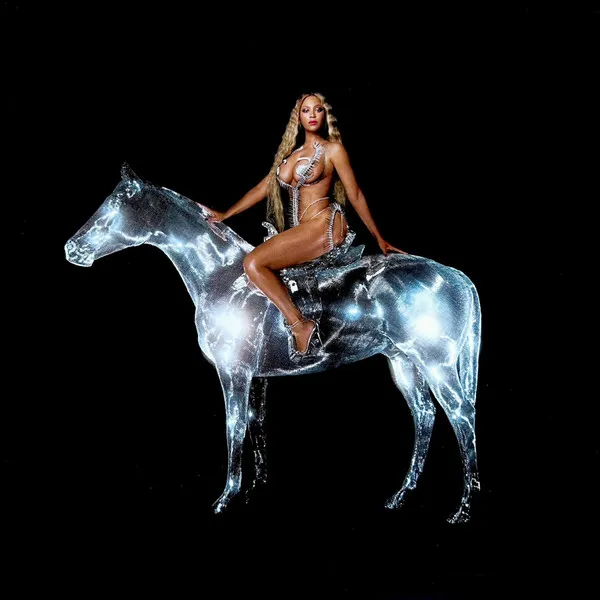 A woman with long blonde hair in a silver bodysuit and heels sits sidesaddle atop a glowing, translucent chrome-like horse against a solid black background.