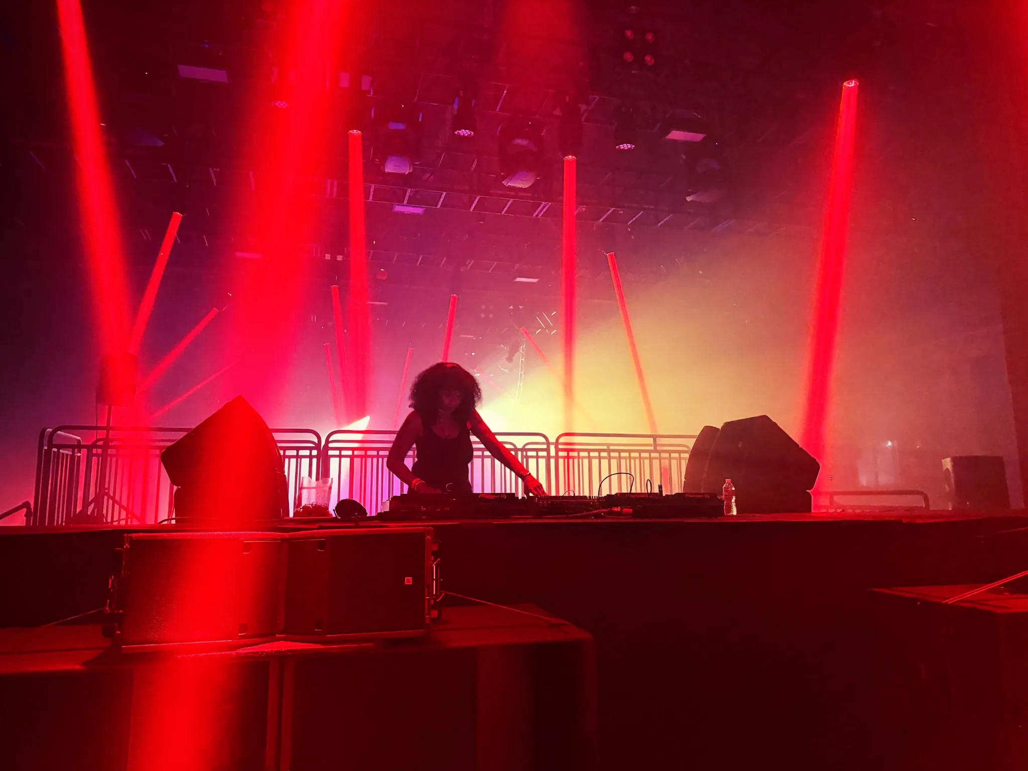 DJ Minx, a legendary artist out of Detroit spins house tracks while backlit by flood lights and lasers in front of a crowd