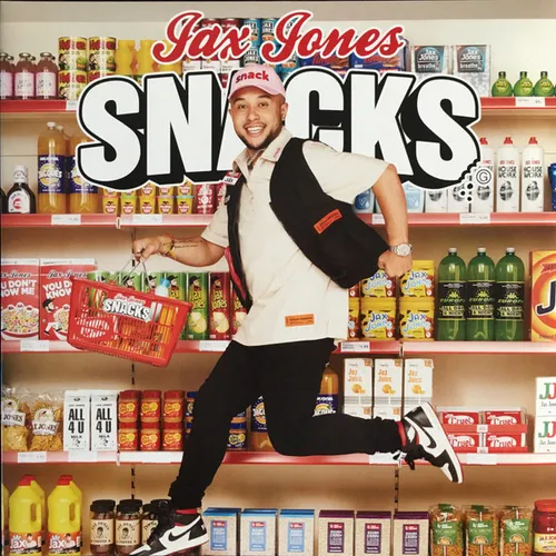 A smiling man in a pink cap, white shirt and black backpack leaps mid-air holding a red shopping basket, in front of brightly stocked supermarket shelves of colorful bottles, boxes and packages, with bold white 3D lettering and red script arching across the top.