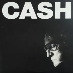 High-contrast black-and-white photo of an older man's face in profile wearing glasses, head bowed and emerging from deep shadow in the lower right, beneath large bold white capital letters across the top of a black background.