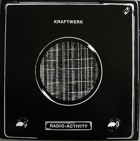 A stark black-and-white, high-contrast illustration of a vintage radio speaker — a large circular mesh grille flanked by two round control knobs and a rectangular label plate, framed by thin white border lines.