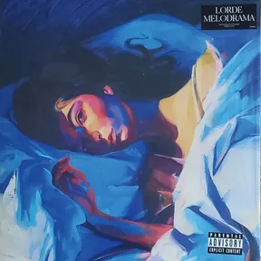 A painterly portrait of a young woman lying on her side amid rumpled bedsheets, rendered in bold blue, violet, and warm gold brushstrokes, her face lit dramatically as she gazes toward the viewer.
