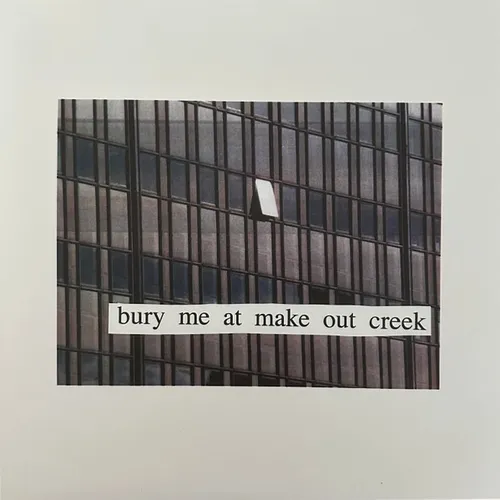 A photograph of a grid-like glass office building facade in muted grey and brown tones, with one small window ajar, mounted on an off-white background and overlaid with a cut-out white paper strip bearing black serif text.