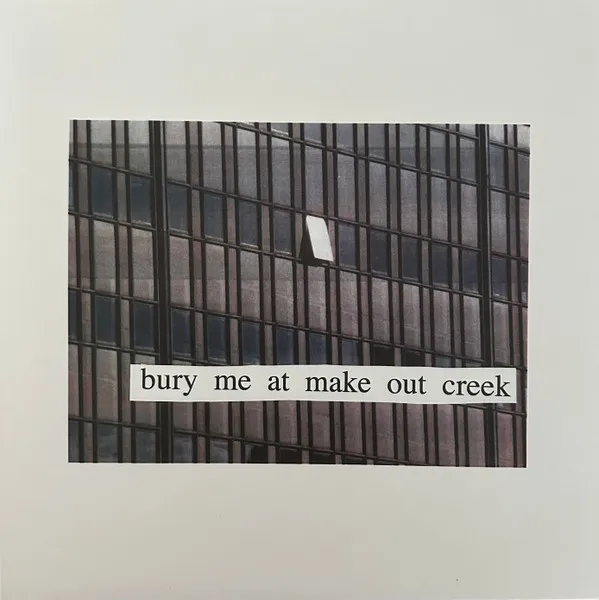 A photograph of a grid-like glass office building facade in muted grey and brown tones, with one small window ajar, mounted on an off-white background and overlaid with a cut-out white paper strip bearing black serif text.