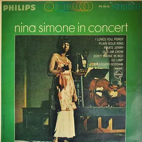 A green-bordered LP sleeve featuring a grainy stage photograph of a woman in a long pale patterned gown standing beside instruments in dim light, with a track list in cream type to the right.