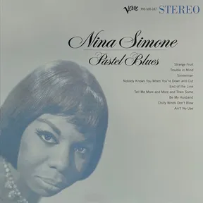 A pale blue-tinted portrait of a woman with short dark hair gazing directly at the viewer, her face filling the lower left of the frame against a soft gradient background, with elegant script and a track list in the upper right.