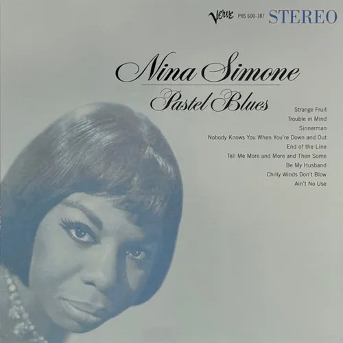 A pale blue-tinted portrait of a woman with short dark hair gazing directly at the viewer, her face filling the lower left of the frame against a soft gradient background, with elegant script and a track list in the upper right.