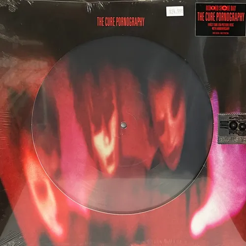 A shrink-wrapped picture disc vinyl whose surface bears a blurred, heavily distorted red and magenta image of three ghostly faces against black, with matching smeared imagery extending onto the sleeve.