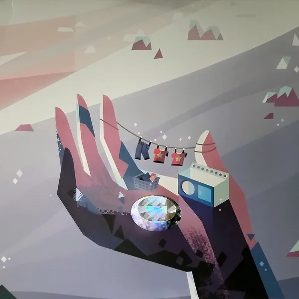 A flat, geometric illustration in muted pinks, teals and greys of a large open hand cradling a sparkling faceted gem, a washing machine, a small house and a clothesline strung with tiny shirts, set against a stylized mountain landscape.